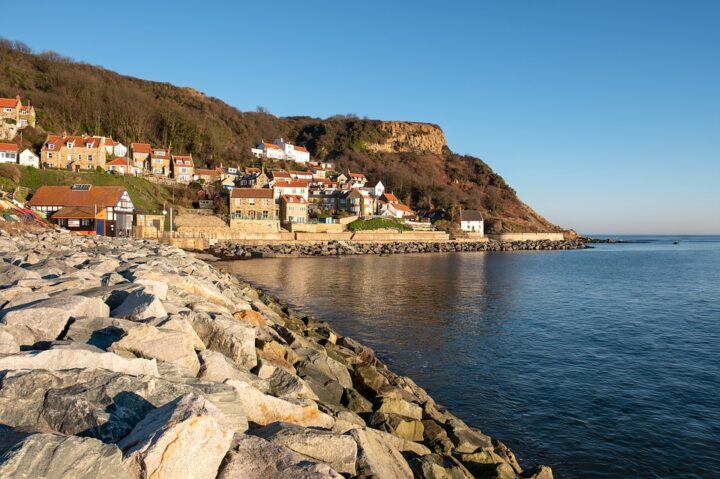 ...Runswick Bay, a picturesque cliffside village with steep, winding streets.